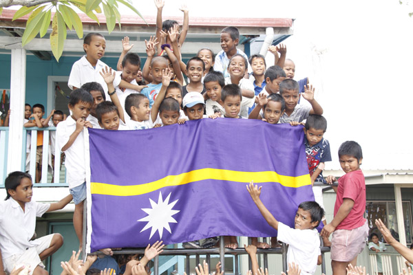 Nauruan children holding the flag of Nauru